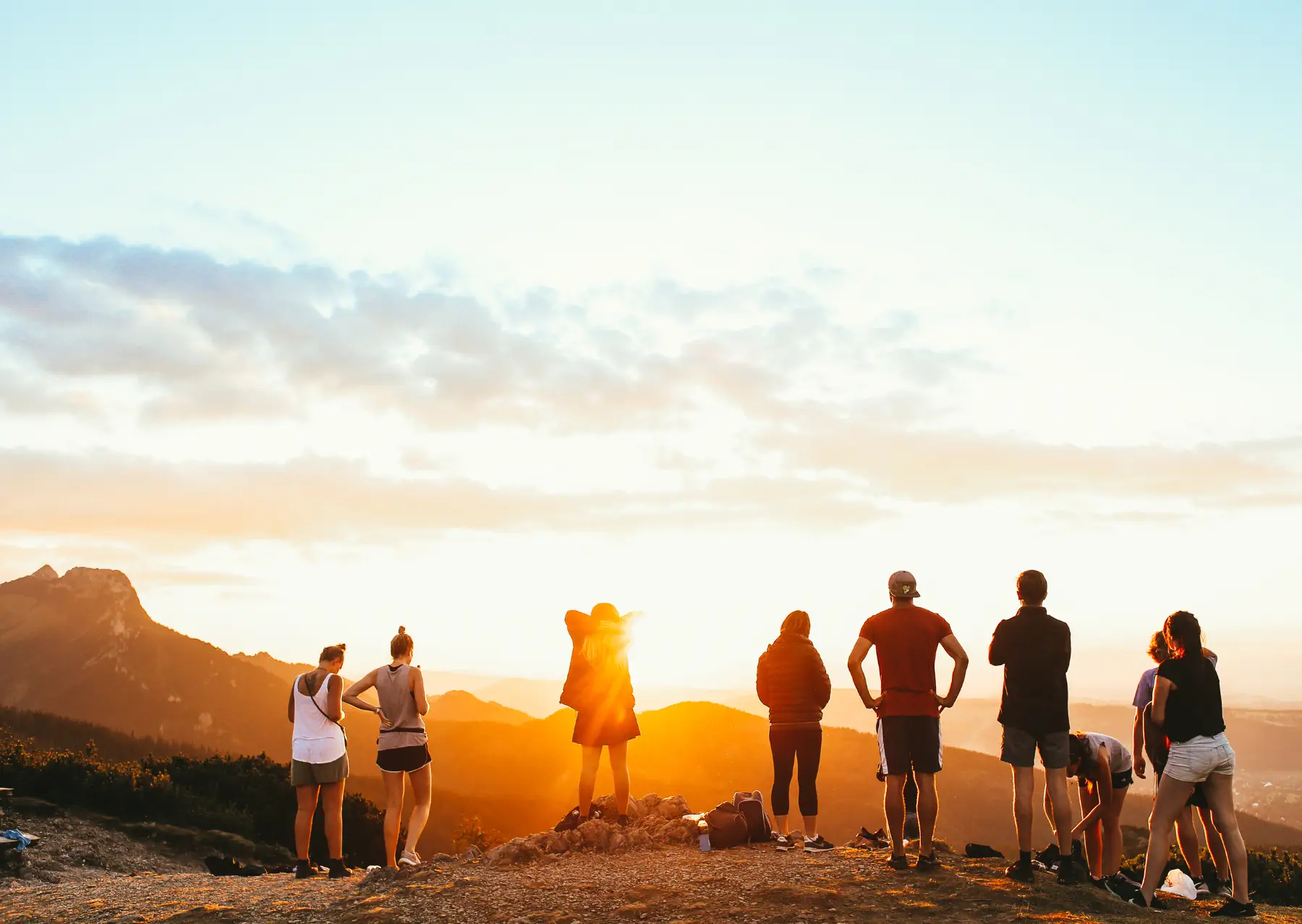 Groupe de voyageurs devant un coucher de soleil après une randonnée